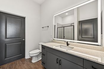 A bathroom with a white toilet, sink, and mirror.  at The Sophia, Venice, FL, 34275